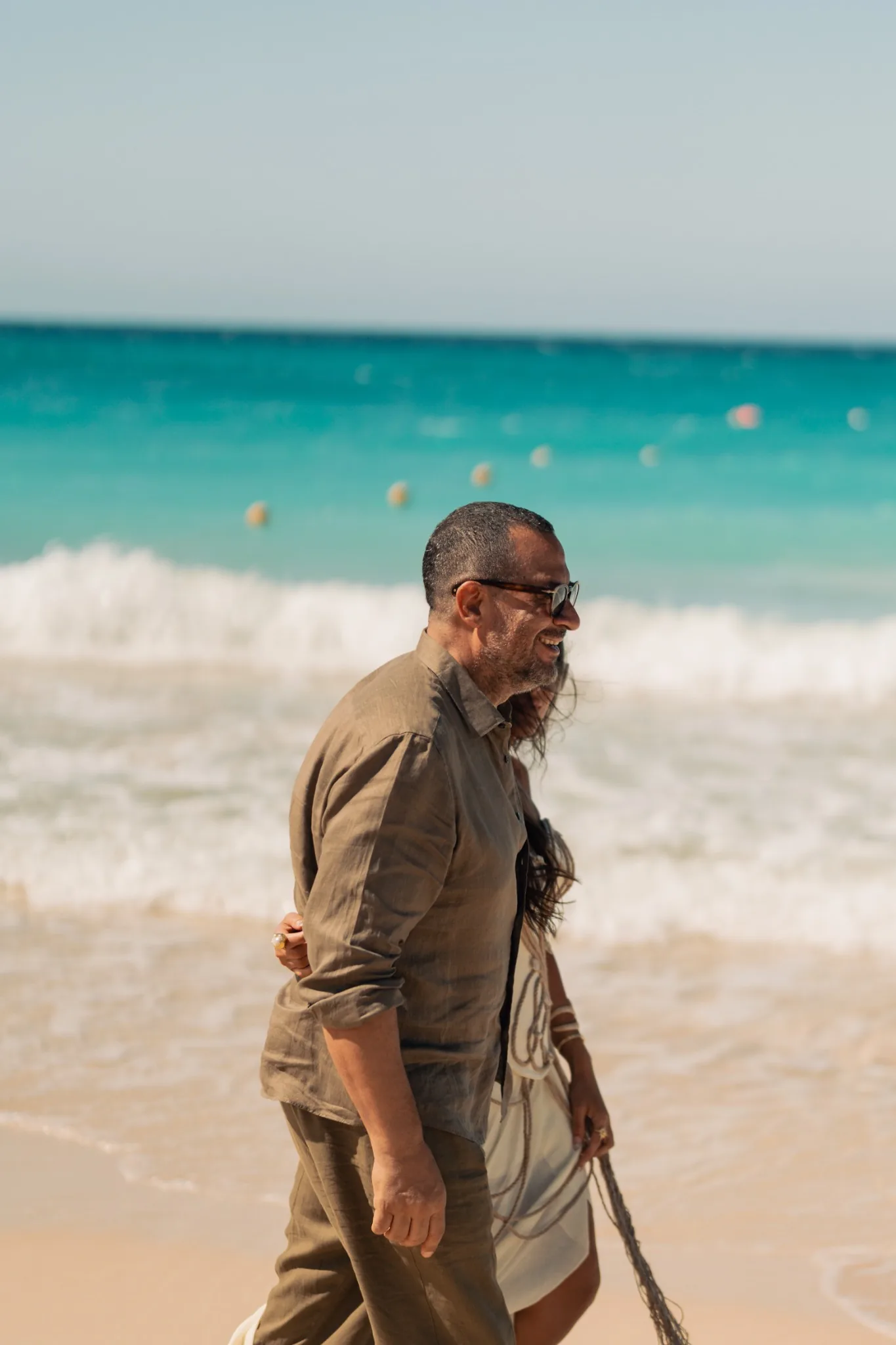 Guests walking beside the Mediterranean waves